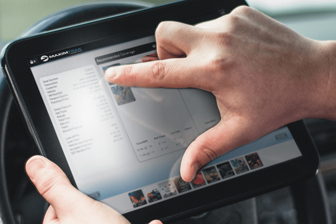 Hands holding tablet on steering wheel